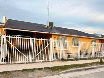Fachada con estacionamiento techado y acceso vehicular.